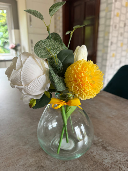 Yellow and white flower arrangement in a beautiful glass vase