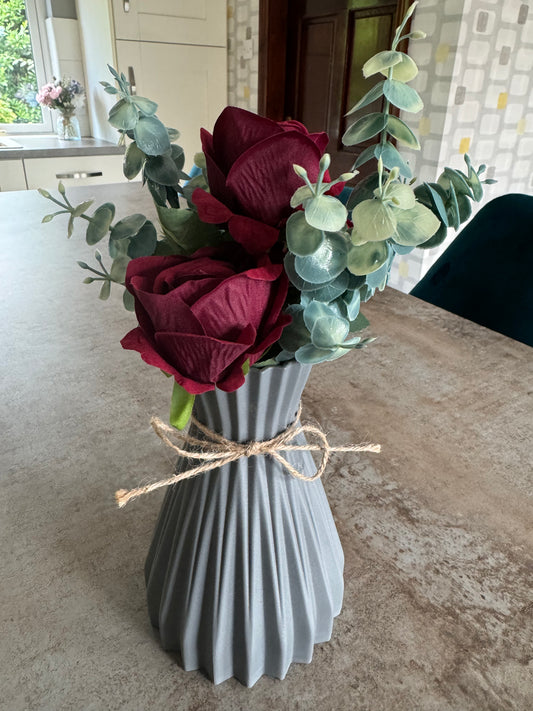 Deep red roses in grey ripple vase