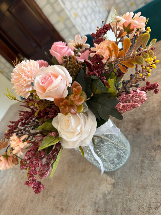 A beautiful autumn arrangement in a frosted glass vase with handle