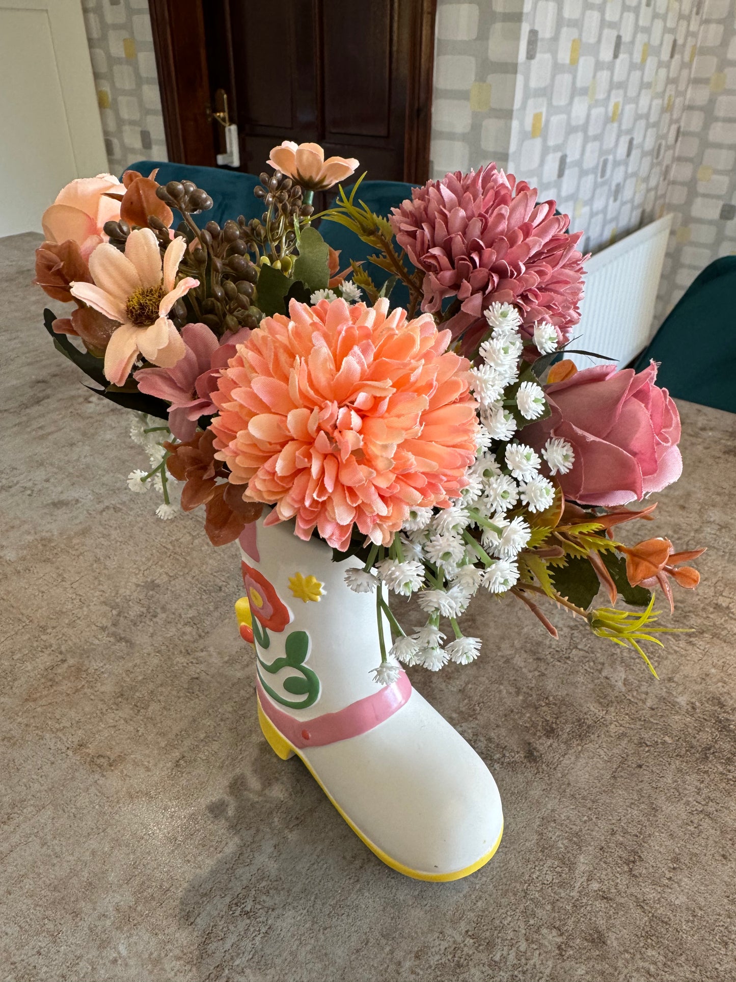 A beautiful ceramic cowboy boot with stunning mix of artificial flowers