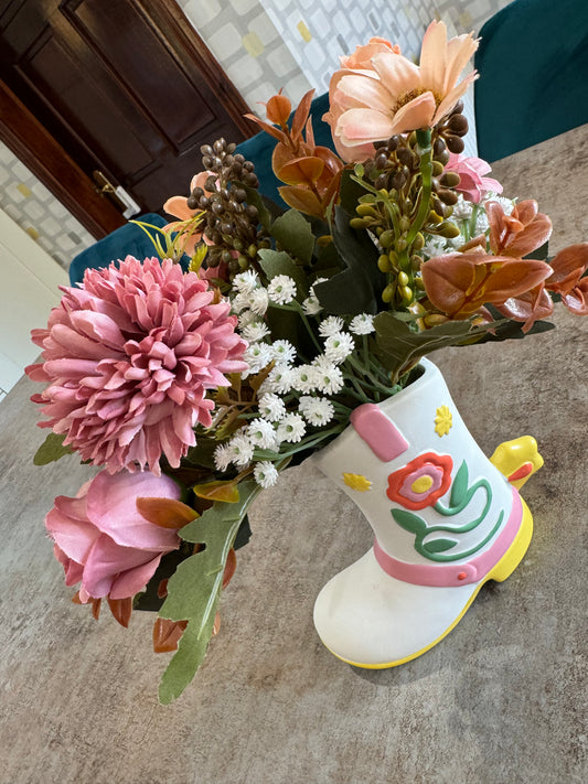 A beautiful ceramic cowboy boot with stunning mix of artificial flowers